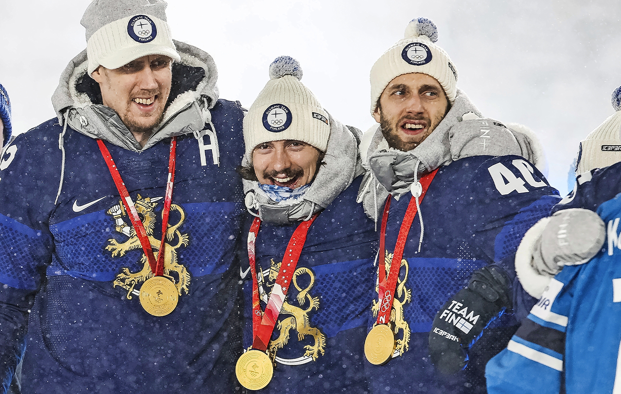 Marko Anttila, Hannes Björninen ja Petteri Lindbohm seisovat vierekkäin olympiakultamitalit kaulassaan.